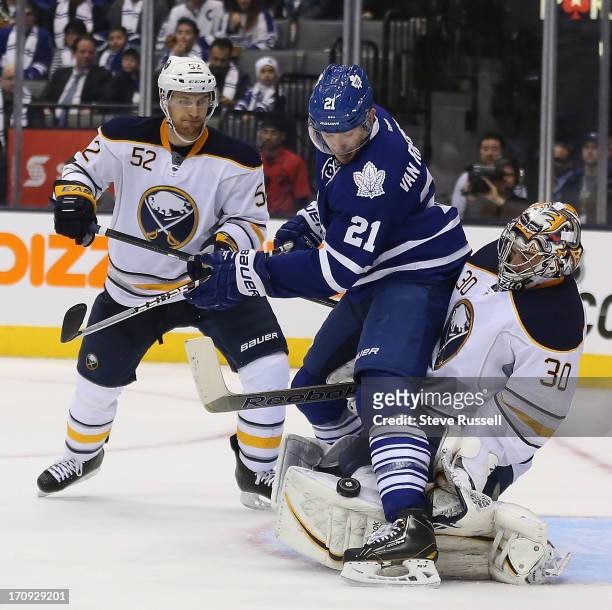 Buffalo Sabres goalie Ryan Miller makes a stop with James van Riemsdyk all over him in front of Alexander Sulzer in third period action as the...