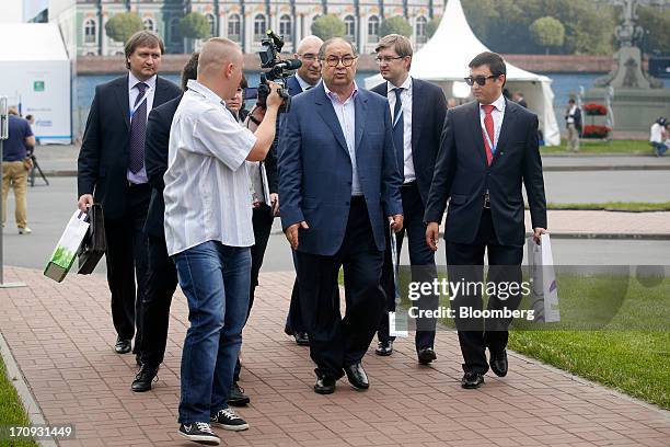 Alisher Usmanov, Russian billionaire owner of USM Holdings Ltd., center, leaves with his entourage following a Bloomberg Television interview on the...