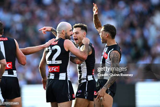 Steele Sidebottom of the Magpies celebrates with Bobby Hill of the Magpies and Jamie Elliott of the Magpies during the 2023 AFL Grand Final match...