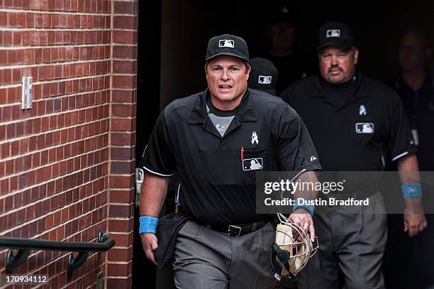 The umpiring crew, including home plate umpire Marvin Hudson and third base umpire Wally Bell emerge from the clubhouse before a game between the...