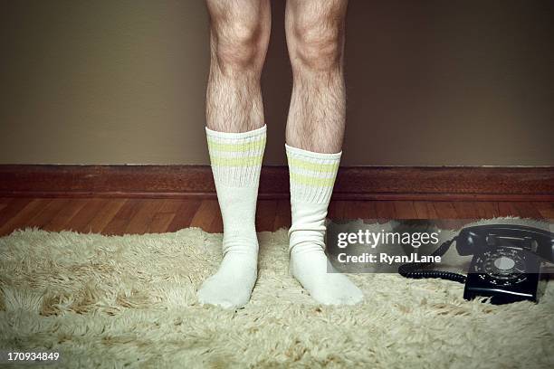 poilu jambes sur tapis à longues mèches avec téléphone - jambes homme photos et images de collection