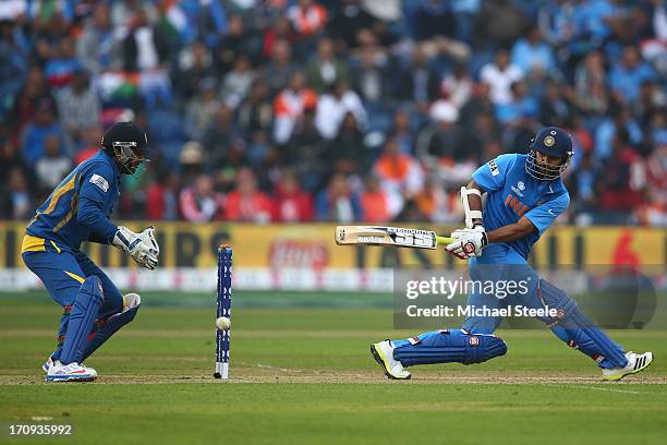 Shikhar Dhawan of India sweeps a delivery as wicketkeeper Kumar Sangakkara of Sri Lanka looks on during the ICC Champions Trophy Semi-Final match...