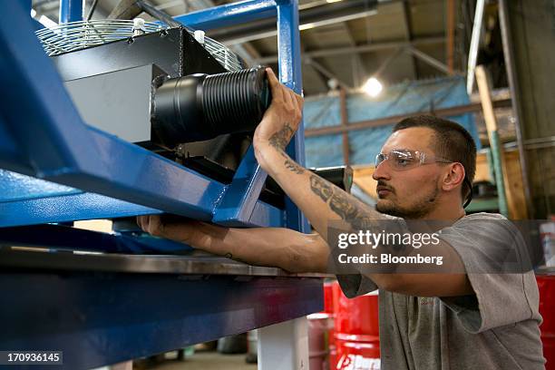 Employee Mike Flynn installs air coolers on a stand in the subassembly area at the Ellicott Dredges LLC manufacturing facility in Baltimore,...