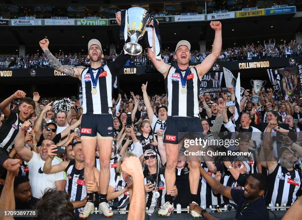 Jeremy Howe of the Magpies and Tom Mitchell of the Magpies celebrate winning with the AFL Premiership Cup during the 2023 AFL Grand Final match...