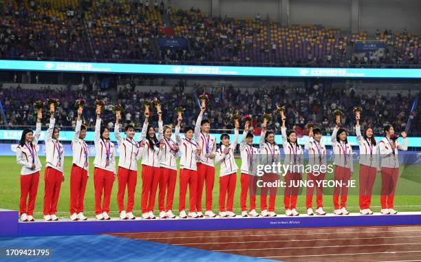 Bronze medalist China's team poses for a photograph during the award ceremony for the women's football match at the 2022 Asian Games in Hangzhou in...