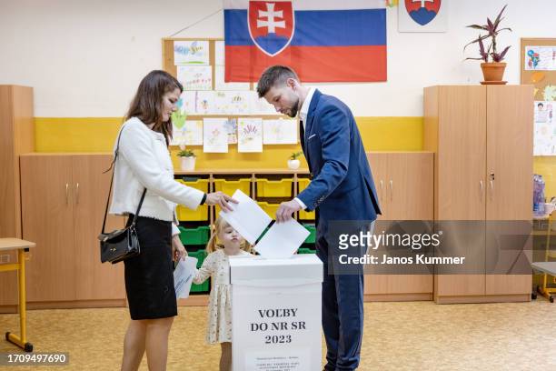 Michal Simecka, lead candidate of Progressive Slovakia political party, casts his ballot with his family at a polling station as voting takes place...