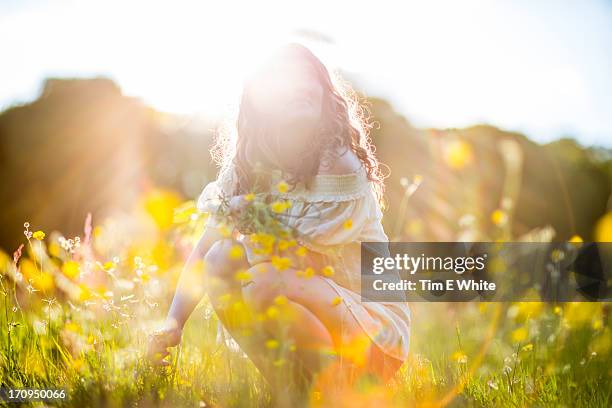 woman in meadow at sunset - mid volwassen vrouw stockfoto's en -beelden