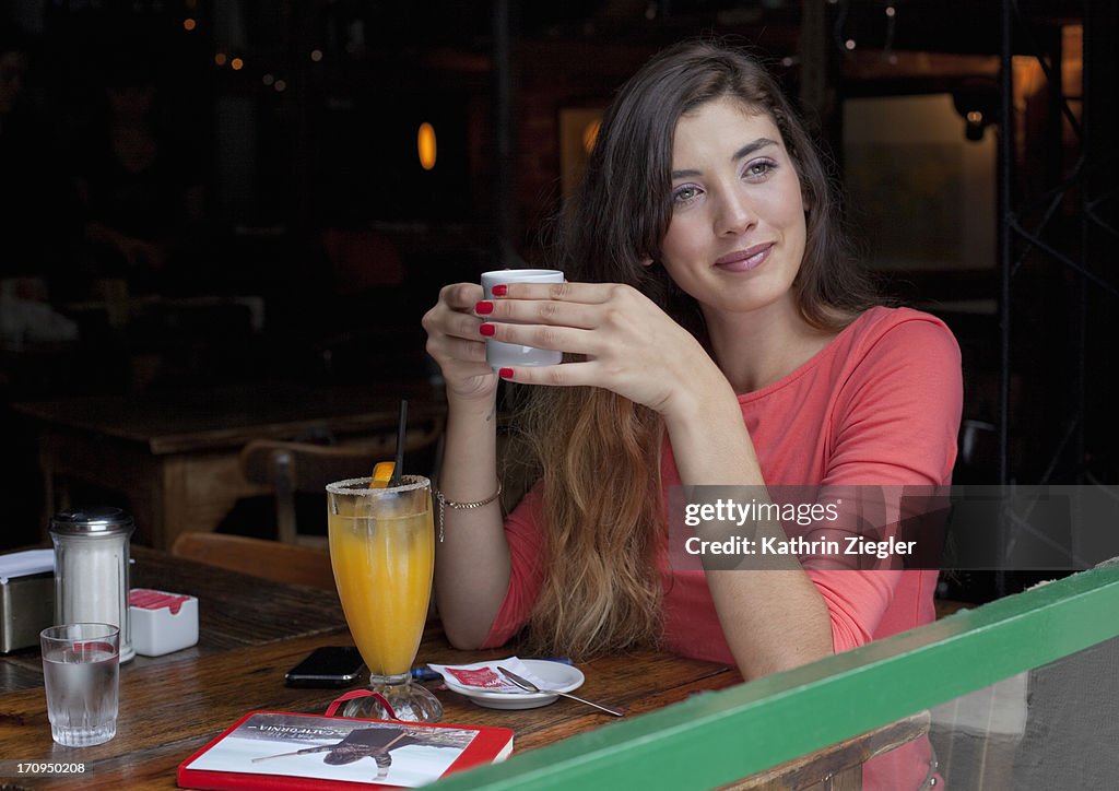 Young woman enjoying coffee and juice at a café