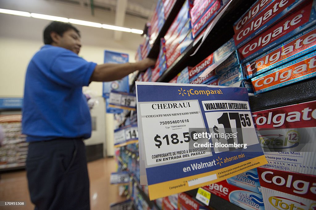 Colgate Toothpaste Racking An employee organizes boxes of Colgate toothpaste on a shelf at a ...