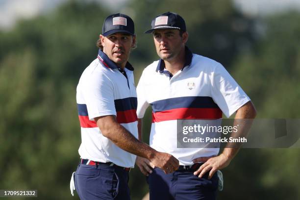 Brooks Koepka and Scottie Scheffler of Team United States react upon losing their match to Viktor Hovland and Ludvig Aberg of Team Europe 9&7 during...