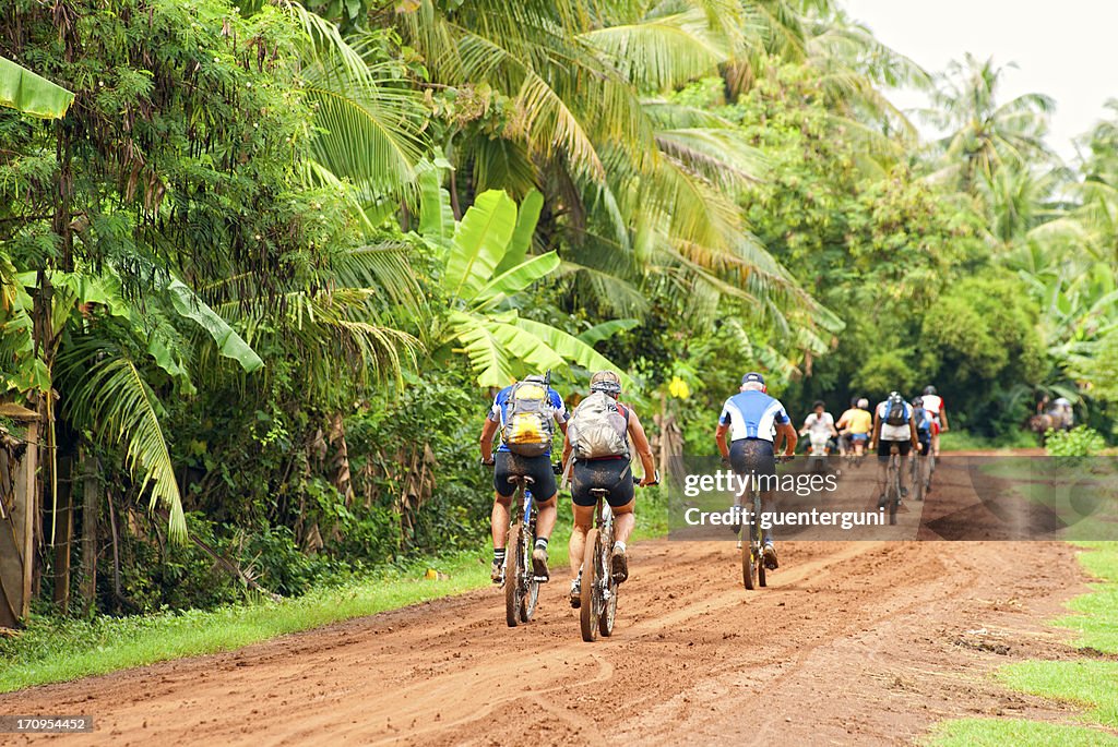 Grupo de la zona oeste de ciclismo de montaña en una carretera de tierra, Camboya