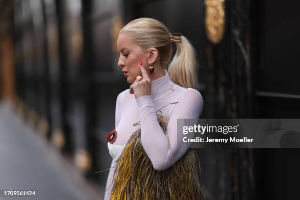Palina Kozyrava seen wearing a Tonia look consisting of a white transparent longsleeve with white collar and flowers embroidered on her breast, wide...