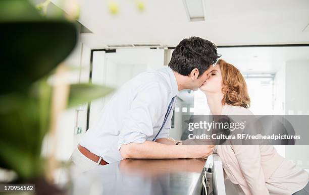 man kissing receptionist - kantoorromance stockfoto's en -beelden