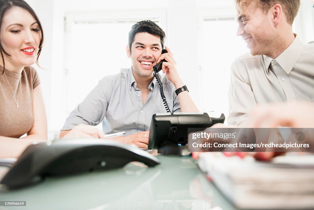 Colleagues in meeting, man on telephone