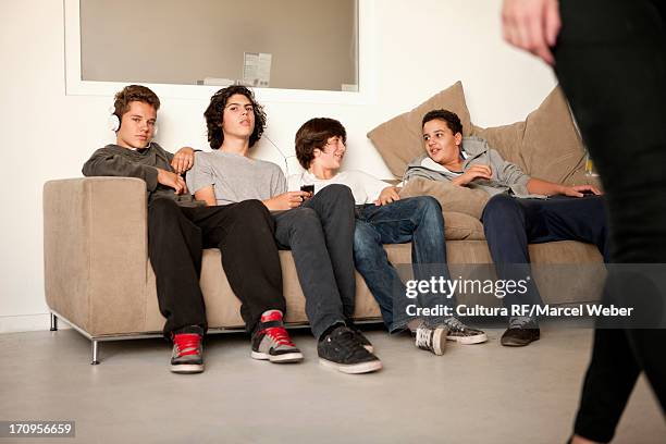 teenage boys sitting on sofa - alleen tienerjongens stockfoto's en -beelden