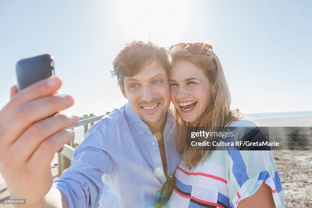 Couple on beach photographing themselves