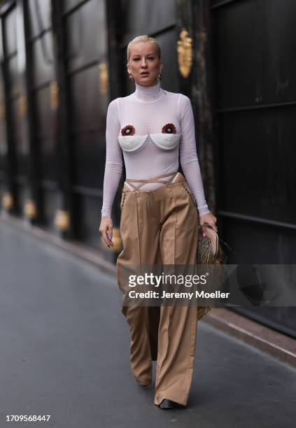 Palina Kozyrava seen wearing a Tonia look consisting of a white transparent longsleeve with white collar and flowers embroidered on her breast, wide...