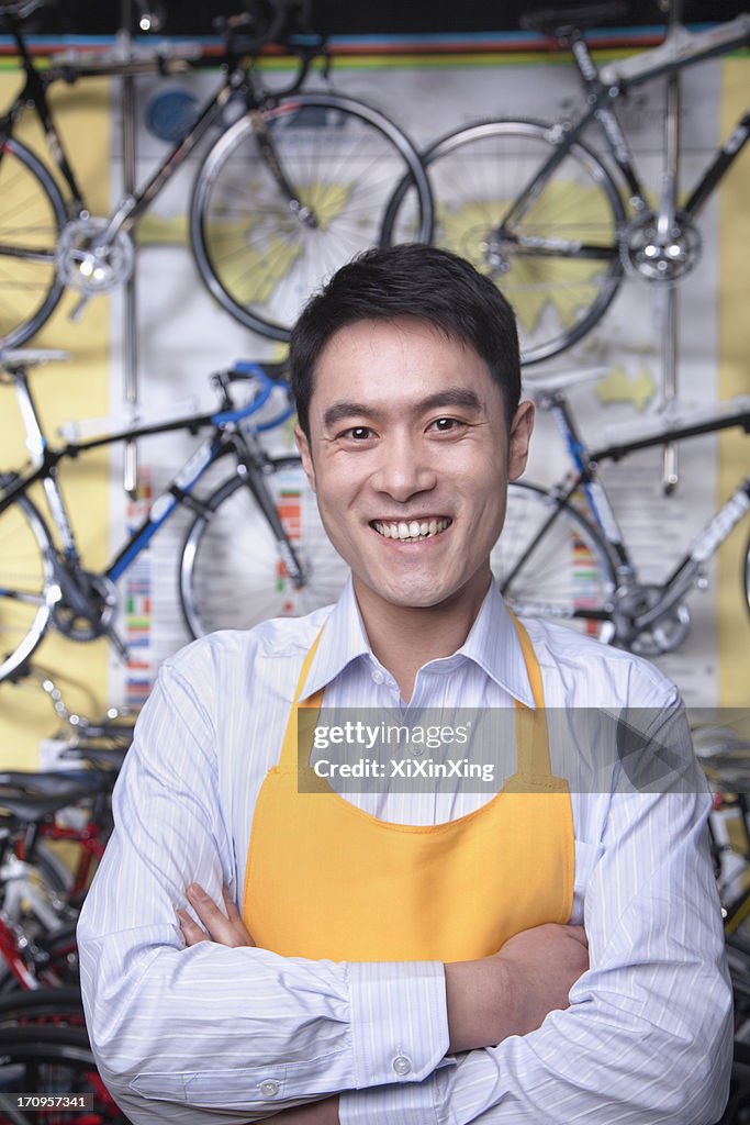 Portrait of young male mechanic in bicycle store, Beijing