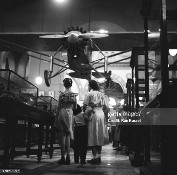 Mother and her daughter look at an exhibit at the Smithsonian Institution's National Air and Space Museum, Washington DC, 1948. Charles Lindbergh's...
