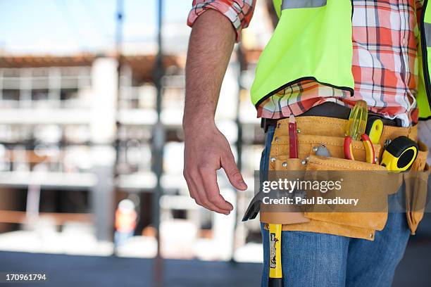 primo piano di un operaio edile uomo strumento cintura sul luogo di costruzione - cintura per gli attrezzi foto e immagini stock