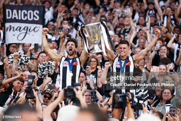 Josh Daicos of the Magpies and Nick Daicos of the Magpies hold aloft the 2023 AFL Premiership Cup after winning the 2023 AFL Grand Final match...
