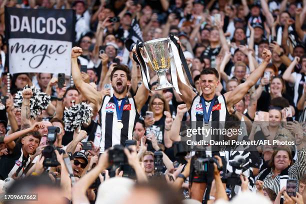 Josh Daicos of the Magpies and Nick Daicos of the Magpies hold aloft the 2023 AFL Premiership Cup after winning the 2023 AFL Grand Final match...