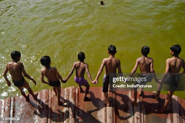 Children jump into water near the India Gate in New Delhi, India.