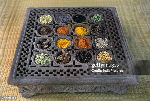 Spices in a carved wooden traditional container, Gujarat, India.