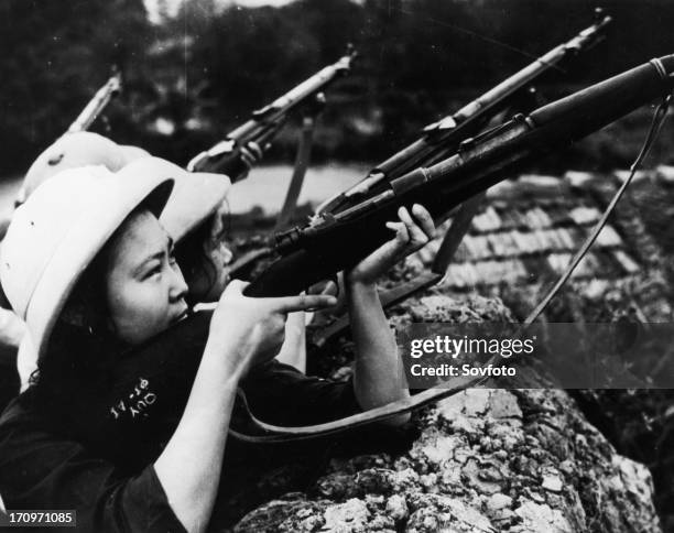 Woman fighters of the self-defense detachment of the march 8 textile mills of hanoi ready to repulse an american air attack, north vietnam, april...