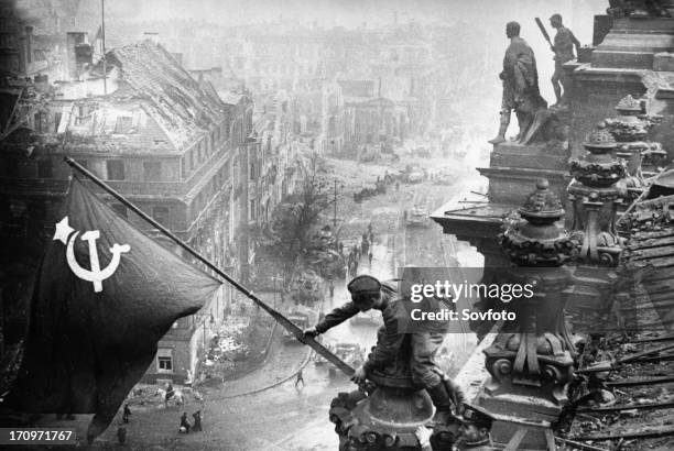 Red army soldiers raising the soviet flag over the reichstag in berlin, germany, april 30, 1945.