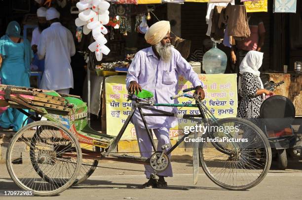 Punjabi rickshaw puller waiting for a customer, Amritsar, Punjab, India .