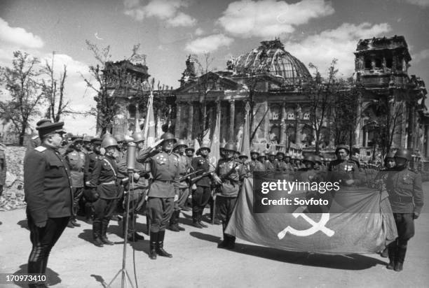 Red army victory ceremony in front of ruined reichstag building, berlin, germany, may 1945.