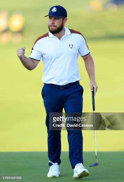 Tyrrell Hatton of England and The European Team celebrates holing a par putt for a half on the first hole in his match with Jon Rahm againjst Patrick...