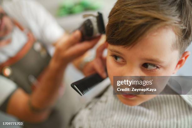 kid is nervously looking to hair clipper - hair clipper stock pictures, royalty-free photos & images