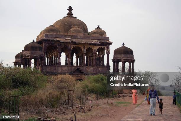 Visitors and pilgrims walk past a Chattri in Ranthambore Fort, Rajasthan, India.