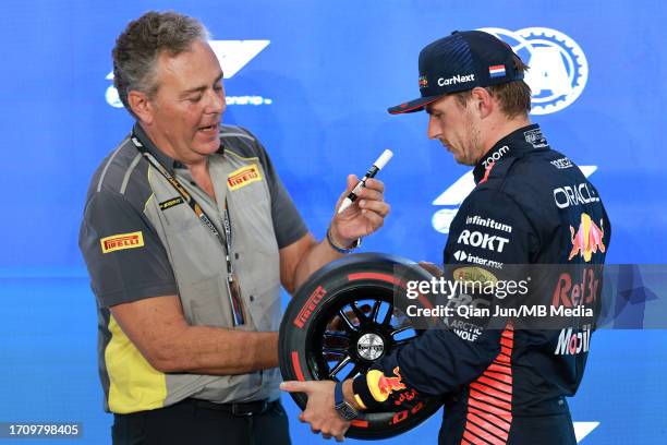 Max Verstappen of the Netherlands and Oracle Red Bull Racing is presented with the pole postion award by Mario Isola of Pirelli in parc feme during...