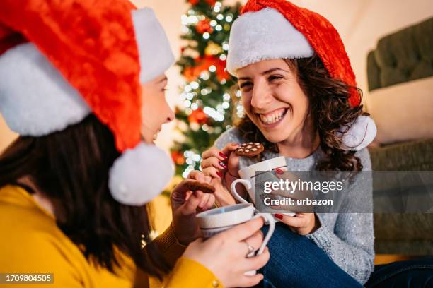 amici che mangiano biscotti al cioccolato e bevono il tè a natale a casa - eating cookies foto e immagini stock