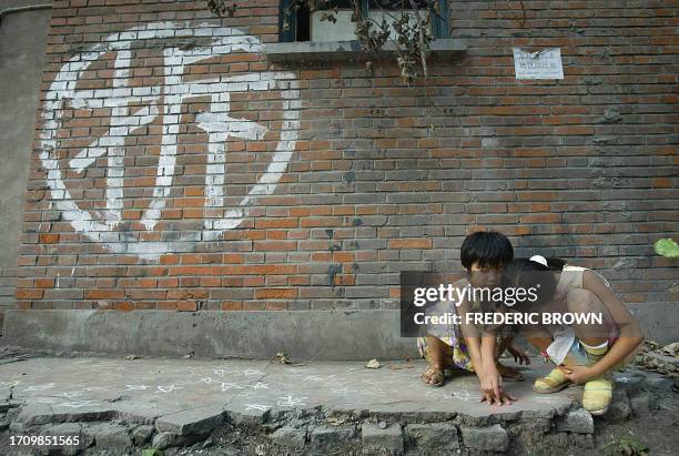 Children try to leave a legacy drawing imprints of their hands with crayon on the floor in front of their soon to be demolished home, marked with the...