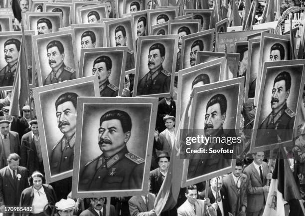 Citizen marchers carrying posters of joseph stalin at a may day parade in bucharest, romania, 1950s.