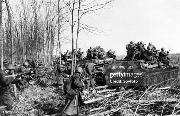 World war 2, red army infantry attacking german positions on the southwestern front, using t-34 tanks for cover.