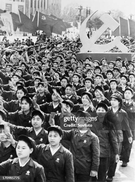 People holding up mao's little red book during a may day demonstration in beijing, china, may 1 cultural revolution.