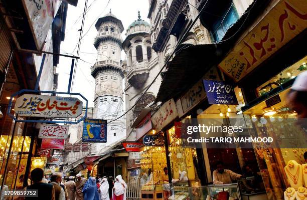 Pakistani people walk in front of the historic Mohabat Khan mosque in Peshawar, 13 March 2006.The Maulana Yousaf Qureshi, prayer leader at the...