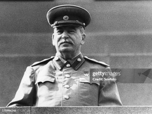 Joseph stalin standing on lenin's tomb in red square, reviewing the may day parade in 1952.