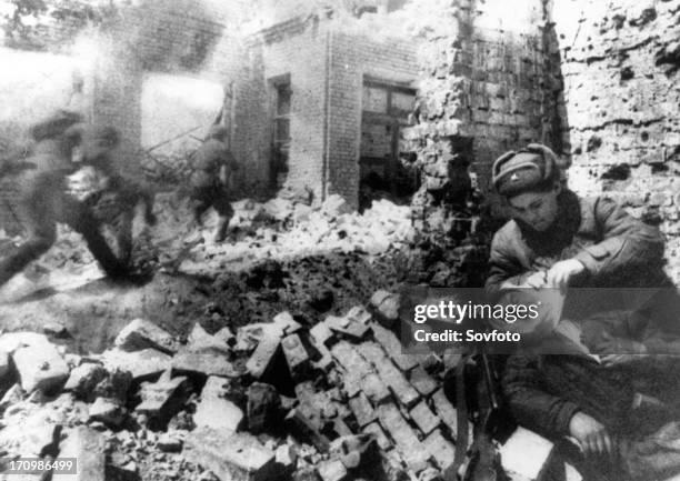 Nurse bandaging a wounded soldier during street fighting in stalingrad, december 1942.