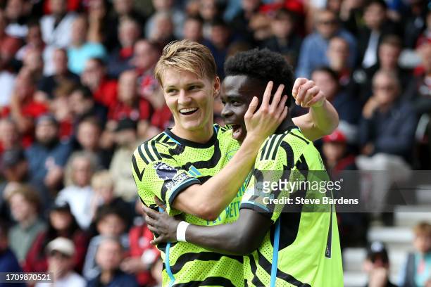 Bukayo Saka of Arsenal celebrates with teammate Martin Oedegaard after scoring the team's first goal during the Premier League match between AFC...