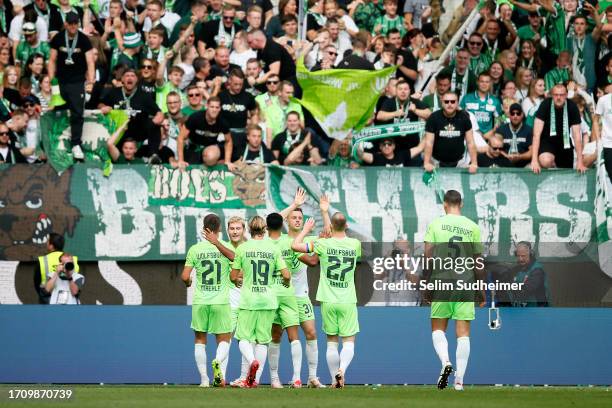 Jonas Wind of VfL Wolfsburg celebrates with teammates after scoring the team's first goal during the Bundesliga match between VfL Wolfsburg and...