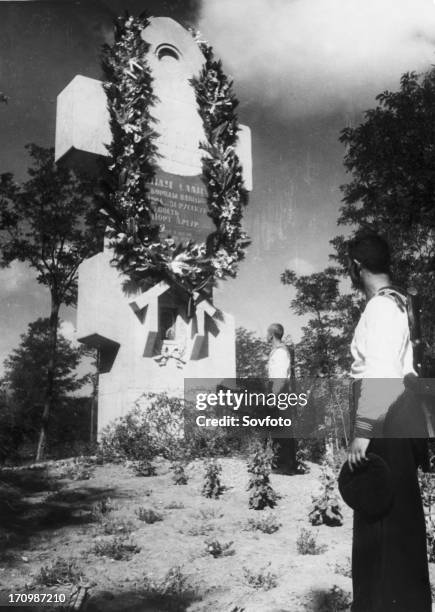 Soviet sailors paying their respects at the monument to russian soldiers killed during the defense of the russian fortress at port arthur in 1904...