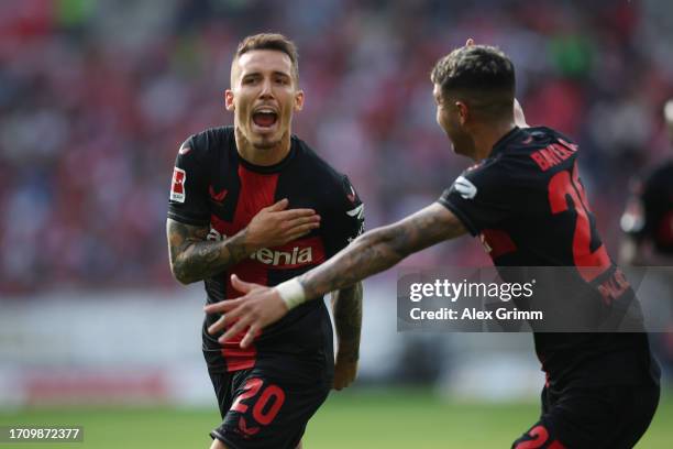 Alex Grimaldo of Bayer Leverkusen celebrates the team's second goal with teammate Exequiel Palacios during the Bundesliga match between 1. FSV Mainz...