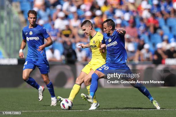 Nemanja Maksimovic of Getafe CF competes for the ball with Juan Marcos Foyth of Villarreal CF during the LaLiga EA Sports match between Getafe CF and...