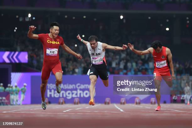 Xie Zhenye of China crosses the finish line to win the men's 100m final athletics event during day 7 of the of the 19th Asian Games at Hangzhou...